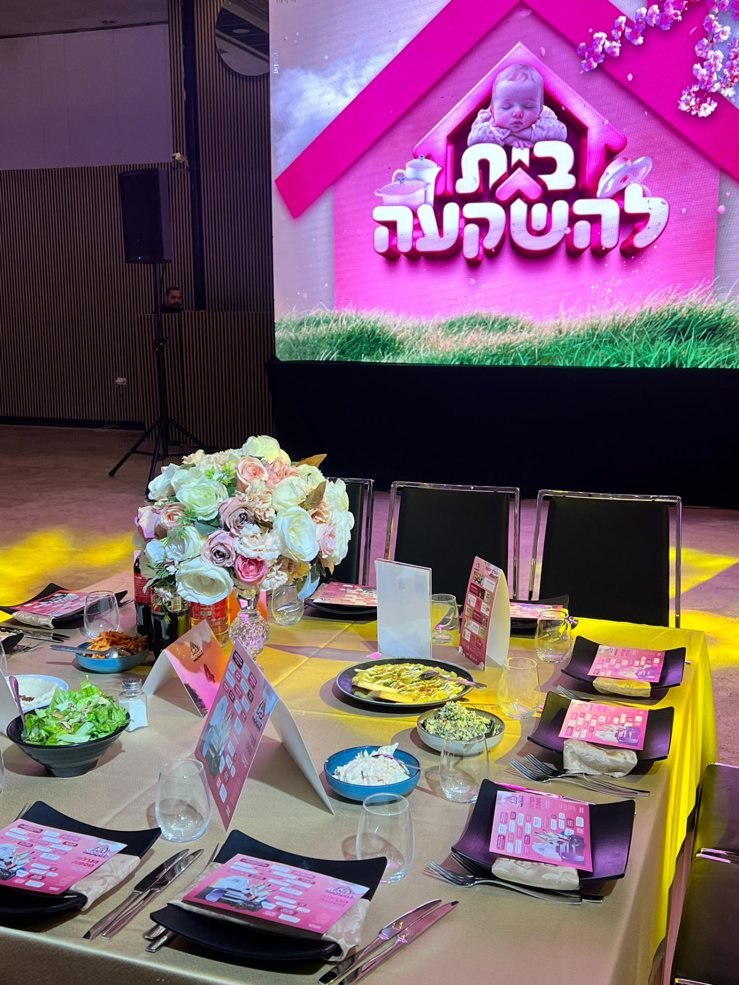 שולחן ערוך מול מסך הבמה בדינר ״בית להשקעה״